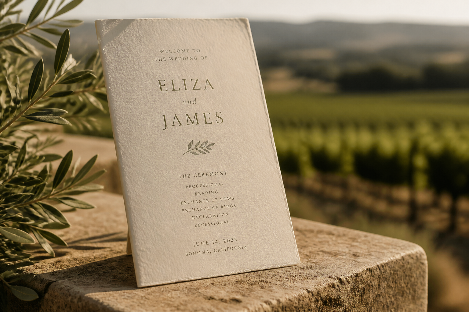 Minimalist wedding program on textured paper in a vineyard setting.