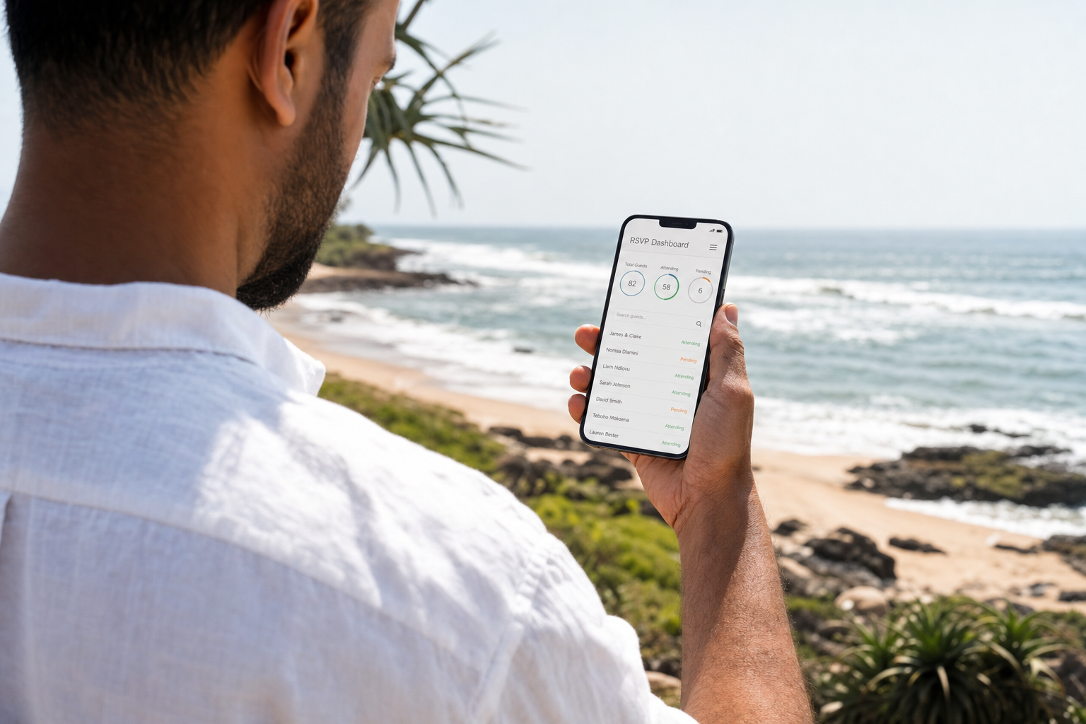 A groom-to-be checking wedding RSVPs on a mobile-optimised wedding website at the beach.
